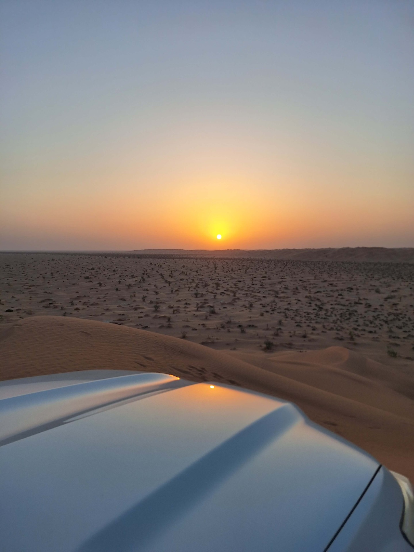Terénní vozy 4x4 na písečných dunách pouště Rub al Khali v Ománu při západu slunce