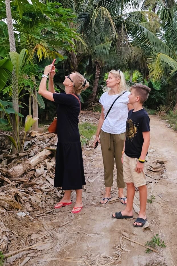 Žena ukazuje na palmy na farmě v Salalah